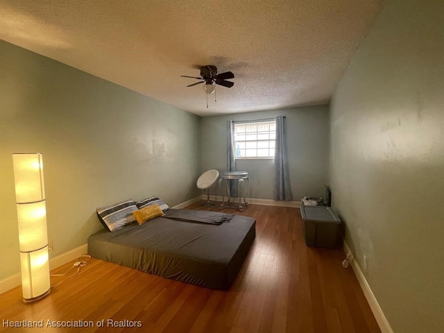 bedroom featuring ceiling fan, a textured ceiling, and hardwood / wood-style flooring