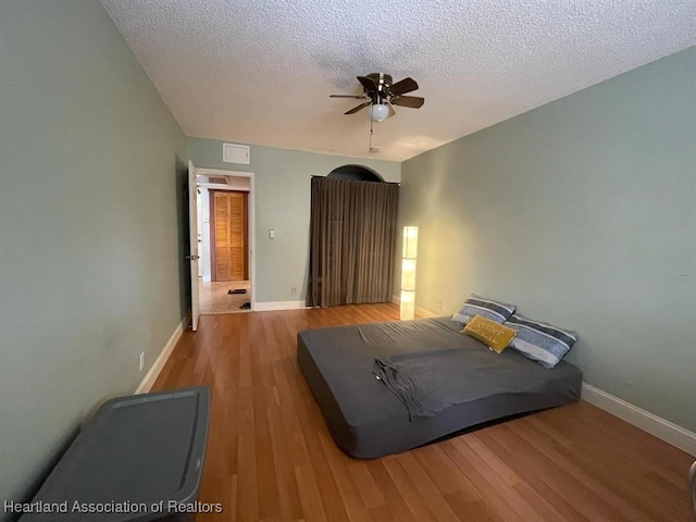 unfurnished bedroom featuring ceiling fan, hardwood / wood-style floors, and a textured ceiling