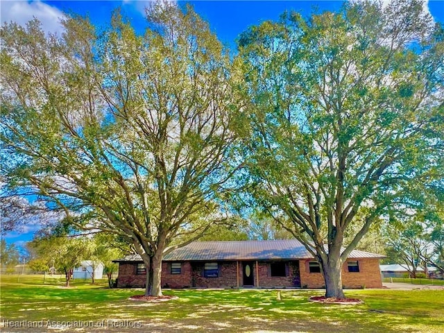 ranch-style house featuring brick siding and a front yard