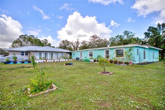 rear view of house featuring a yard