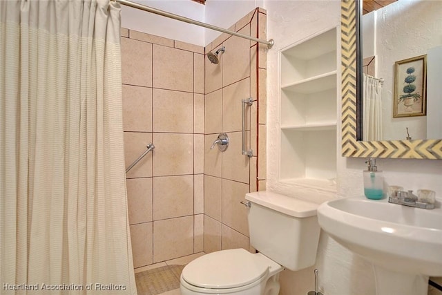 bathroom featuring built in shelves, toilet, sink, and walk in shower