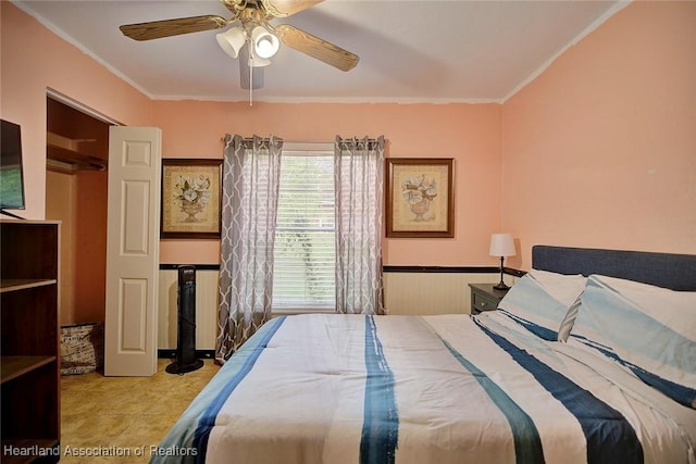 tiled bedroom with ceiling fan and crown molding