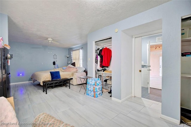 living room featuring ceiling fan and a textured ceiling