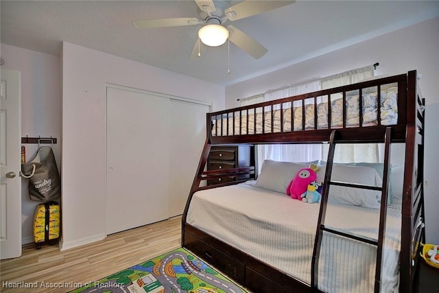 bedroom with ceiling fan, wood-type flooring, and a closet