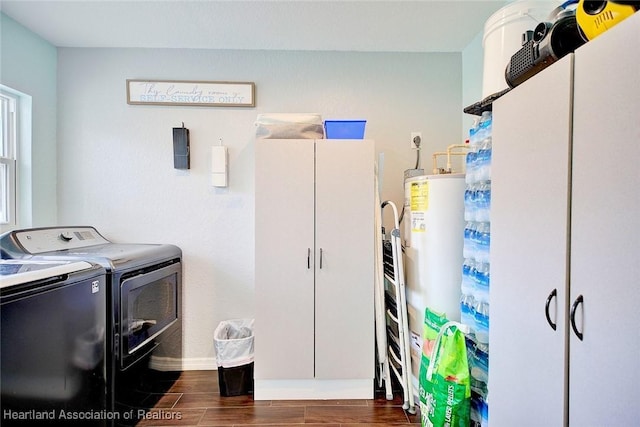 laundry room featuring gas water heater, separate washer and dryer, and cabinets