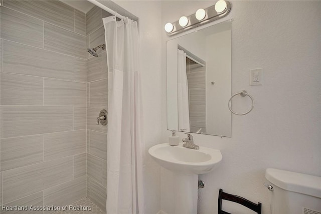 bathroom featuring a shower with curtain and toilet