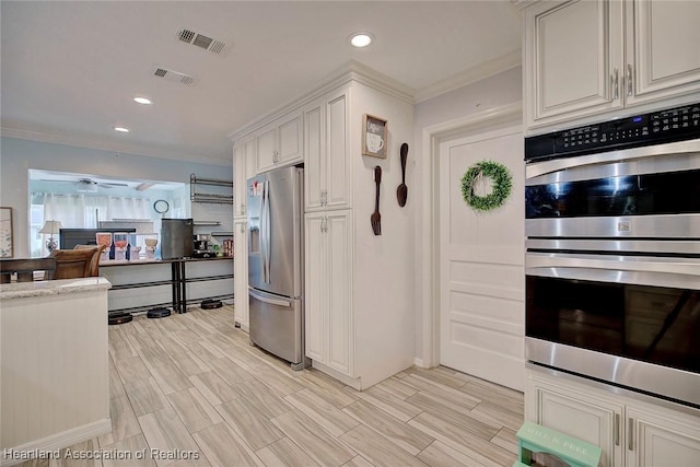 kitchen with stainless steel appliances, white cabinetry, and crown molding