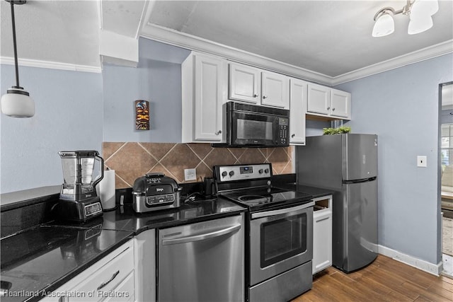 kitchen with hardwood / wood-style floors, white cabinets, hanging light fixtures, ornamental molding, and appliances with stainless steel finishes