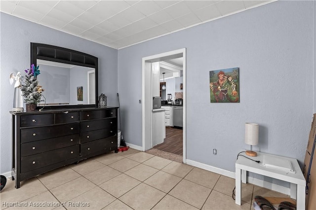 bedroom featuring baseboards and light tile patterned floors