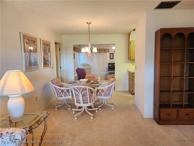 dining area featuring an inviting chandelier and light colored carpet