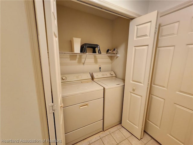 clothes washing area featuring washing machine and clothes dryer and light tile patterned floors