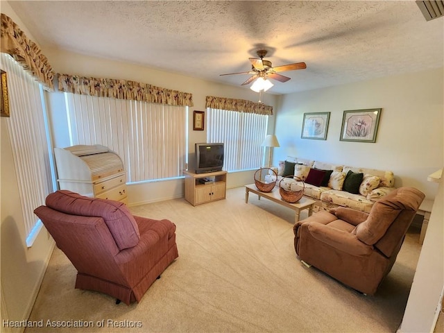 carpeted living room with ceiling fan and a textured ceiling