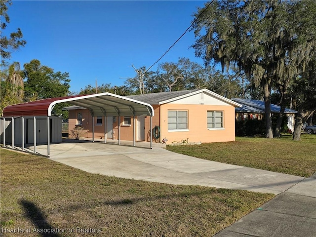 view of front of home featuring a detached carport, concrete driveway, and a front lawn