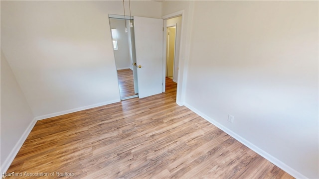 empty room with baseboards and wood finished floors