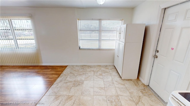 interior space with baseboards and a healthy amount of sunlight