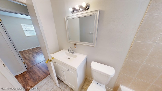 bathroom featuring toilet, wood finished floors, and vanity