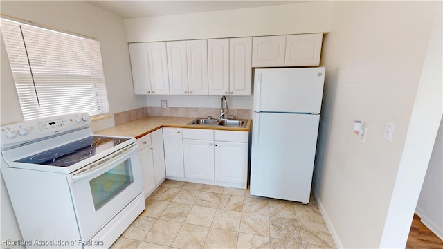 kitchen with white cabinetry, white appliances, light countertops, and a sink