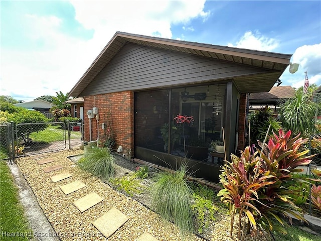 4212 Elson Ave, Sebring, FL 33875 - view of property exterior featuring brick siding, a gate, and a sunroom