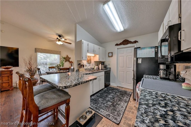 4212 Elson Ave, Sebring, FL 33875 - kitchen with vaulted ceiling, a peninsula, black appliances, a textured ceiling, and ceiling fan