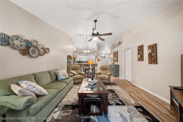 living room featuring lofted ceiling, baseboards, a ceiling fan, and wood finished floors