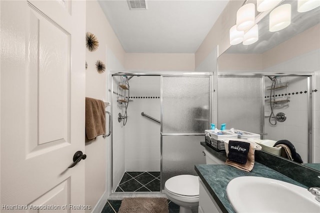 full bathroom featuring vanity, a stall shower, tile patterned flooring, toilet, and visible vents