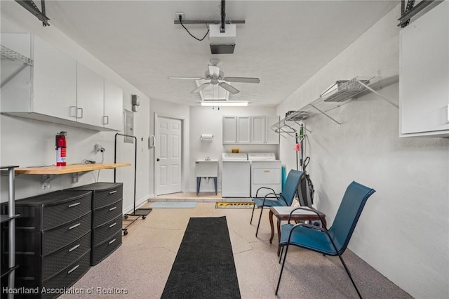 garage featuring a sink, washer and clothes dryer, and a ceiling fan