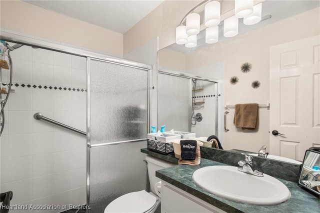full bathroom featuring toilet, vanity, and a stall shower