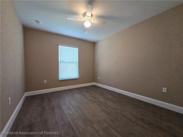 spare room with ceiling fan and dark wood-type flooring