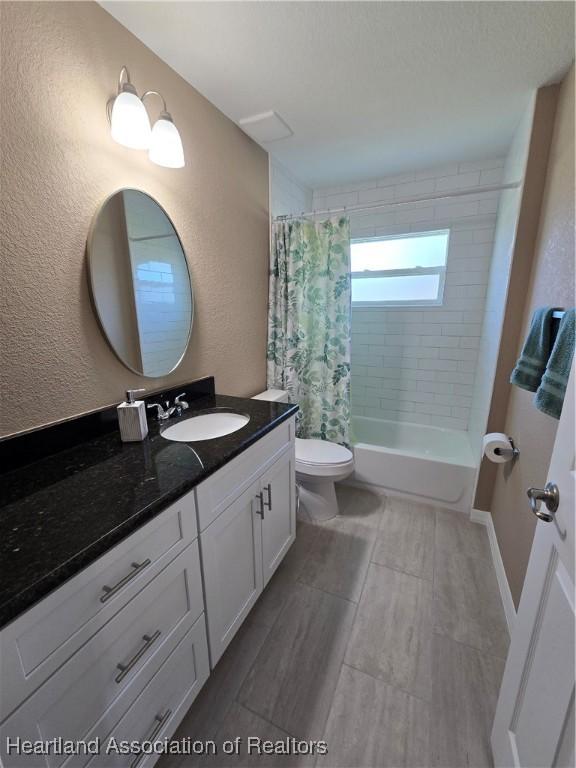 full bathroom featuring shower / bath combo, vanity, and toilet