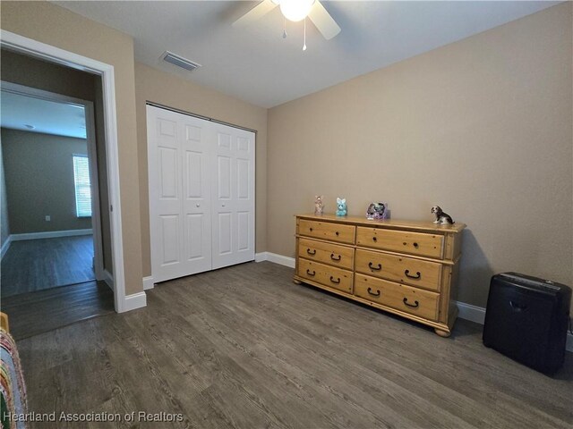 bedroom featuring dark hardwood / wood-style flooring, a closet, and ceiling fan