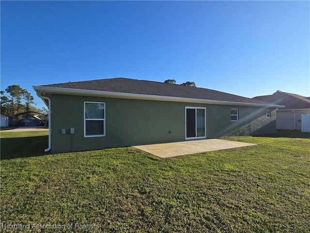 back of property with a yard and a patio area