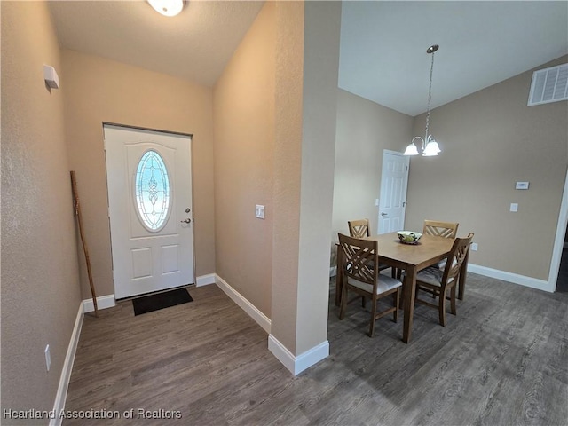 entryway with dark hardwood / wood-style flooring, a chandelier, and lofted ceiling