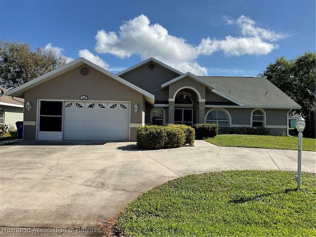 single story home featuring a garage, a front yard, concrete driveway, and stucco siding