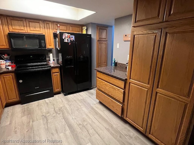 315 Indiana Ave, Wauchula, FL 33873 - kitchen with brown cabinetry, black appliances, and light wood-style floors