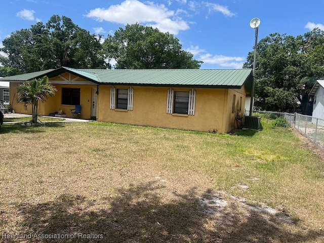 315 Indiana Ave, Wauchula, FL 33873 - ranch-style home featuring a front lawn, fence, stucco siding, and metal roof