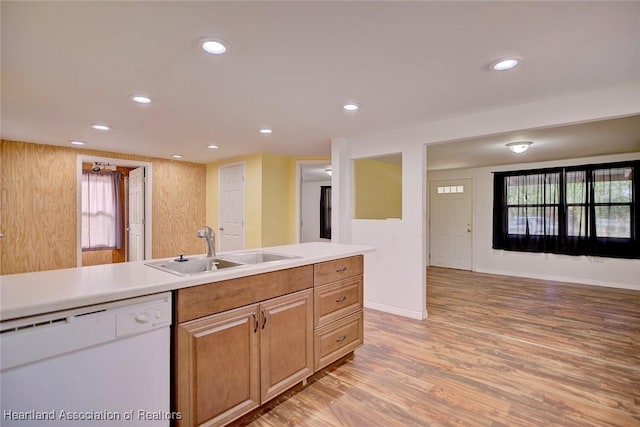 kitchen featuring wood walls, dishwasher, a healthy amount of sunlight, and sink