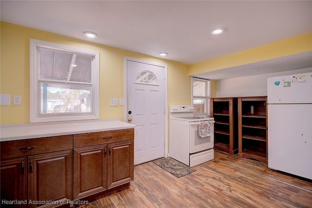 kitchen with light hardwood / wood-style flooring and white appliances