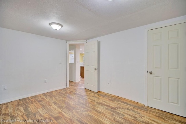 spare room with light hardwood / wood-style flooring and a textured ceiling