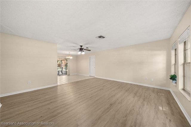 4304 Lewis Ave, Sebring, FL 33875 - unfurnished living room with light wood-type flooring, ceiling fan, and a chandelier