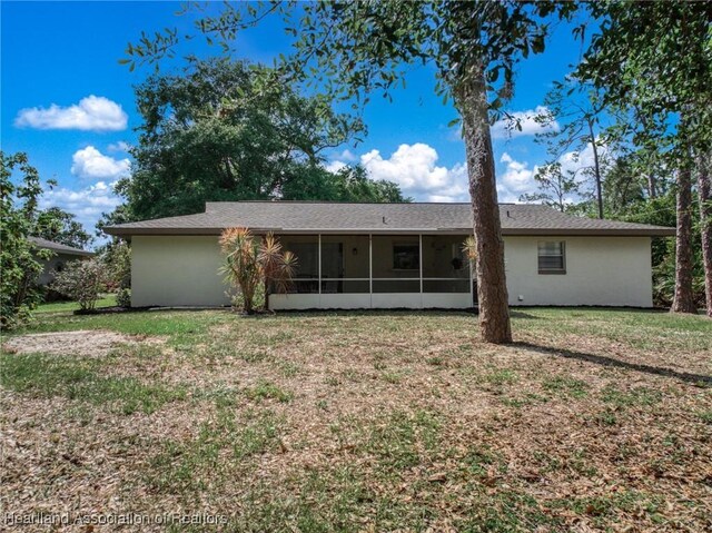4304 Lewis Ave, Sebring, FL 33875 - back of house featuring a sunroom, a lawn, and stucco siding