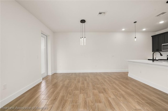 5243 Cortez Blvd, Sebring, FL 33872 - unfurnished living room featuring a sink, light wood finished floors, baseboards, and recessed lighting