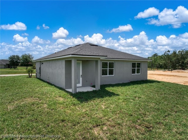 5243 Cortez Blvd, Sebring, FL 33872 - rear view of house featuring stucco siding, a lawn, and roof with shingles