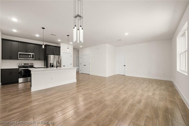 5243 Cortez Blvd, Sebring, FL 33872 - unfurnished living room with recessed lighting, light wood finished floors, baseboards, and a sink