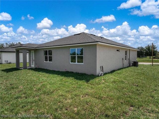5243 Cortez Blvd, Sebring, FL 33872 - back of house with a yard, stucco siding, central air condition unit, and a shingled roof