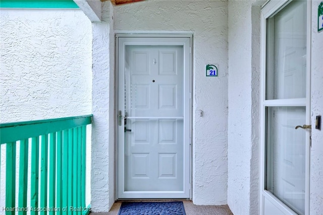 view of exterior entry featuring stucco siding