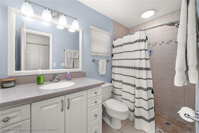 bathroom with tile patterned flooring, vanity, toilet, and walk in shower