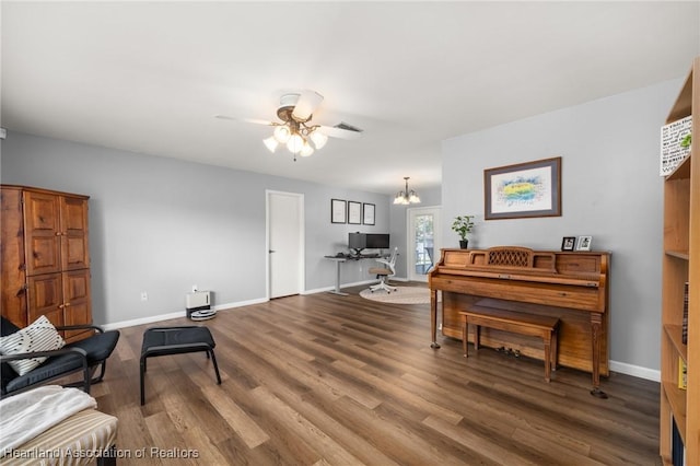 living area with wood-type flooring and ceiling fan with notable chandelier