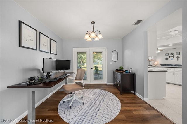 office area with french doors, wood-type flooring, and ceiling fan with notable chandelier