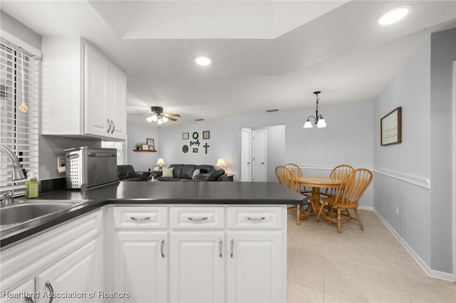 kitchen featuring ceiling fan with notable chandelier, sink, pendant lighting, white cabinets, and light tile patterned flooring