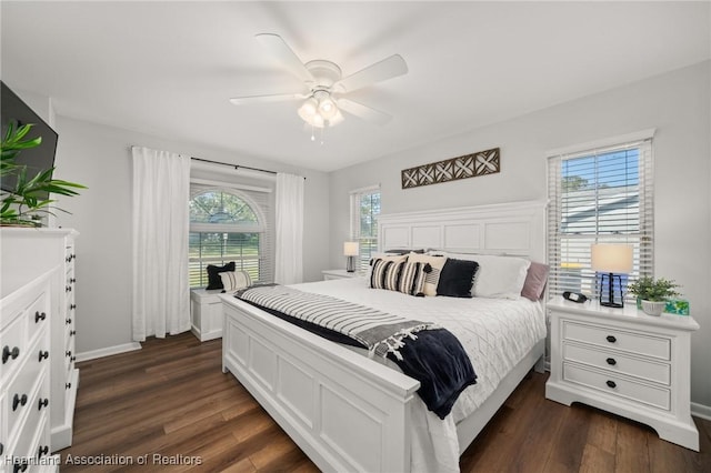 bedroom featuring multiple windows, dark hardwood / wood-style flooring, and ceiling fan